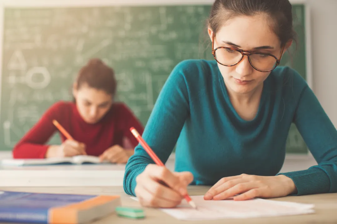 99501822_m Students taking exam writing answer in classroom